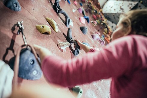 Eine Frau steigt in eine Kletterroute ein