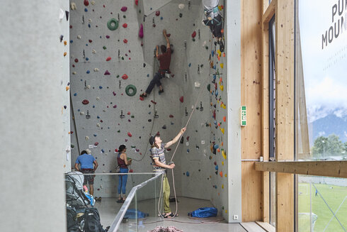 Ein Sportkletterer sichert seinen Partner in der Kletterhalle