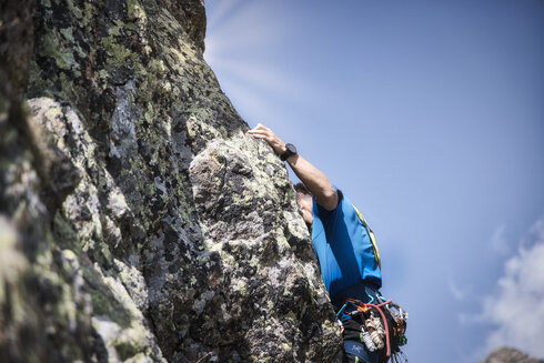 Ein Mann klettert konzentriert in einer Sportkletterroute