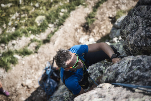 Ein Sportkletterer ist in einer Kletterroute am Klettern. 