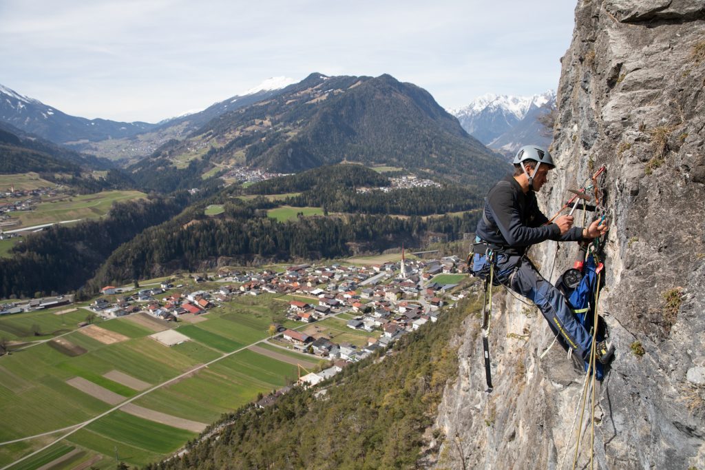 Das Bild zeigt einen Kletterer bei der Wartung von Klettergärten im Climbers Paradise.